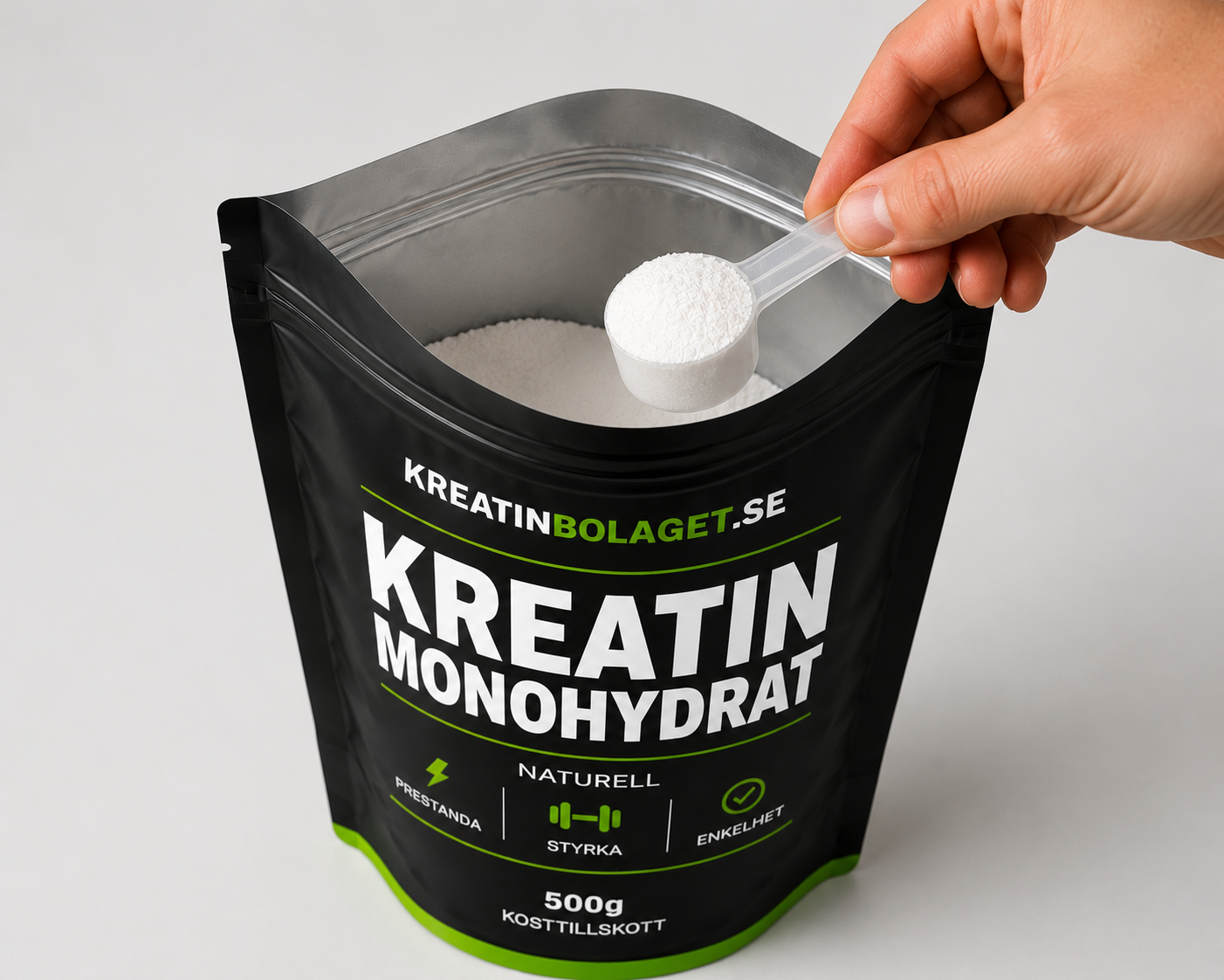 Hand tar en doseringsskopa med kreatin monohydrat från en öppnad påse från Kreatinbolaget.